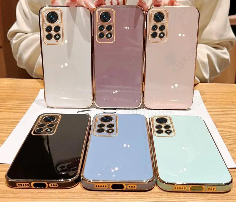 Six smartphones in different pastel colors arranged in two rows on a display surface.