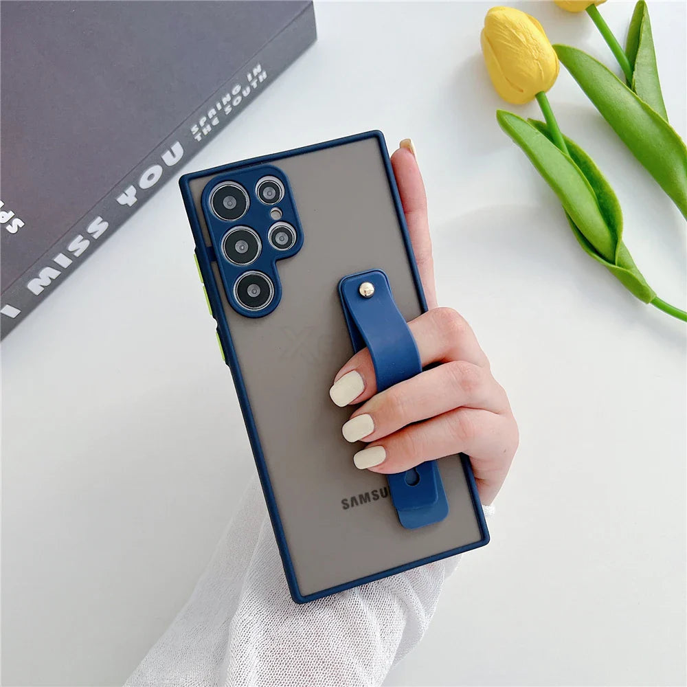 A smartphone with multiple cameras, a transparent case with a blue frame, and an attached blue finger strap.