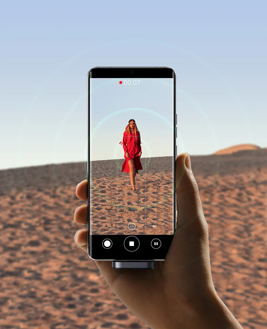 Smartphone displaying a photo of a person in a red outfit standing in a desert landscape.