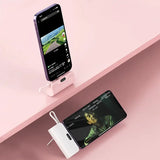 a smartphone and a smartphone stand on a pink surface