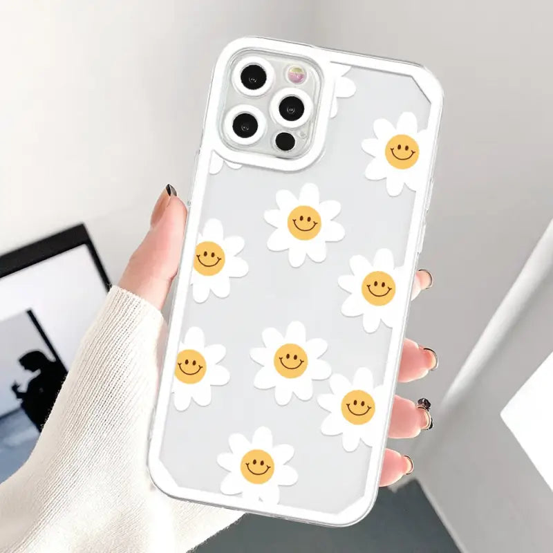a woman holding a phone case with smiley face on it