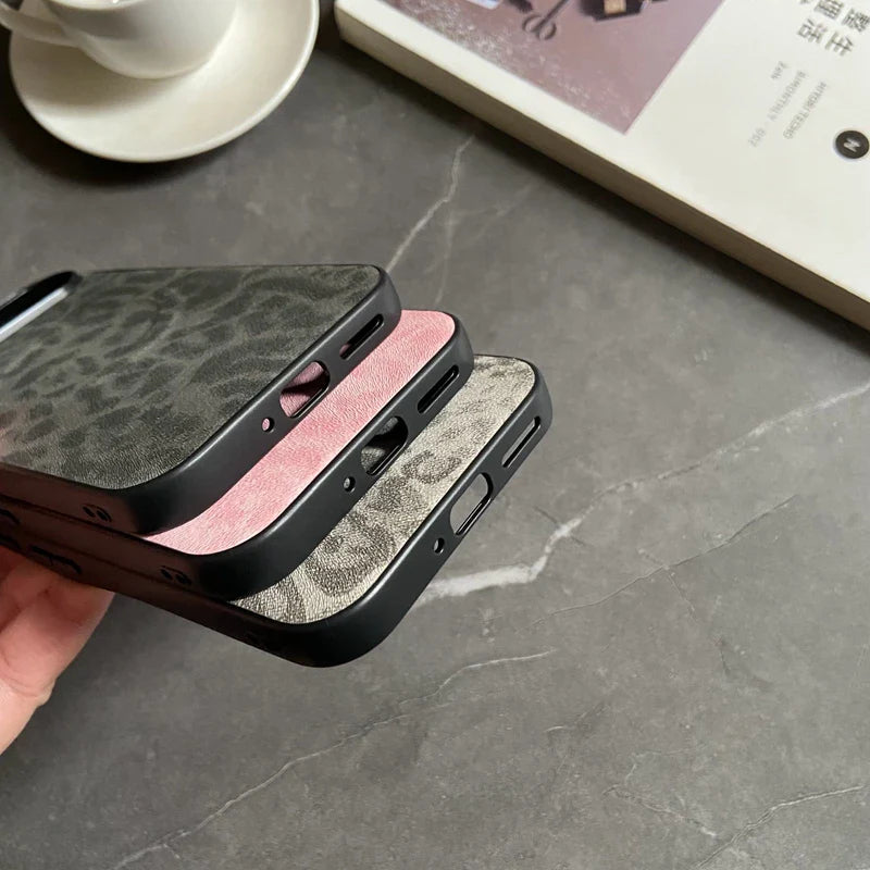 Stacked leopard print phone cases in black, pink, and gray.