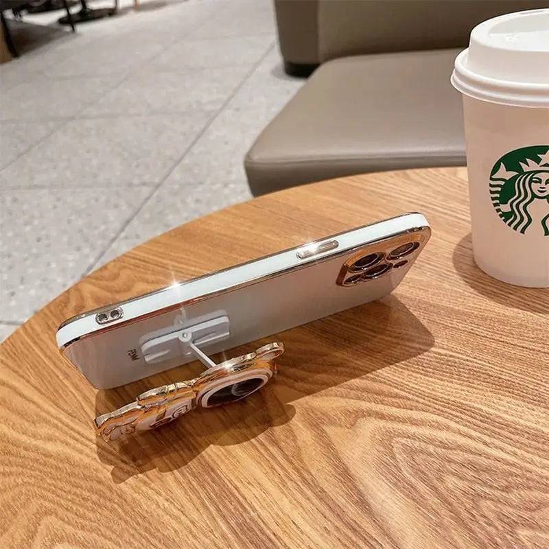 a cup of coffee and a cell phone on a table