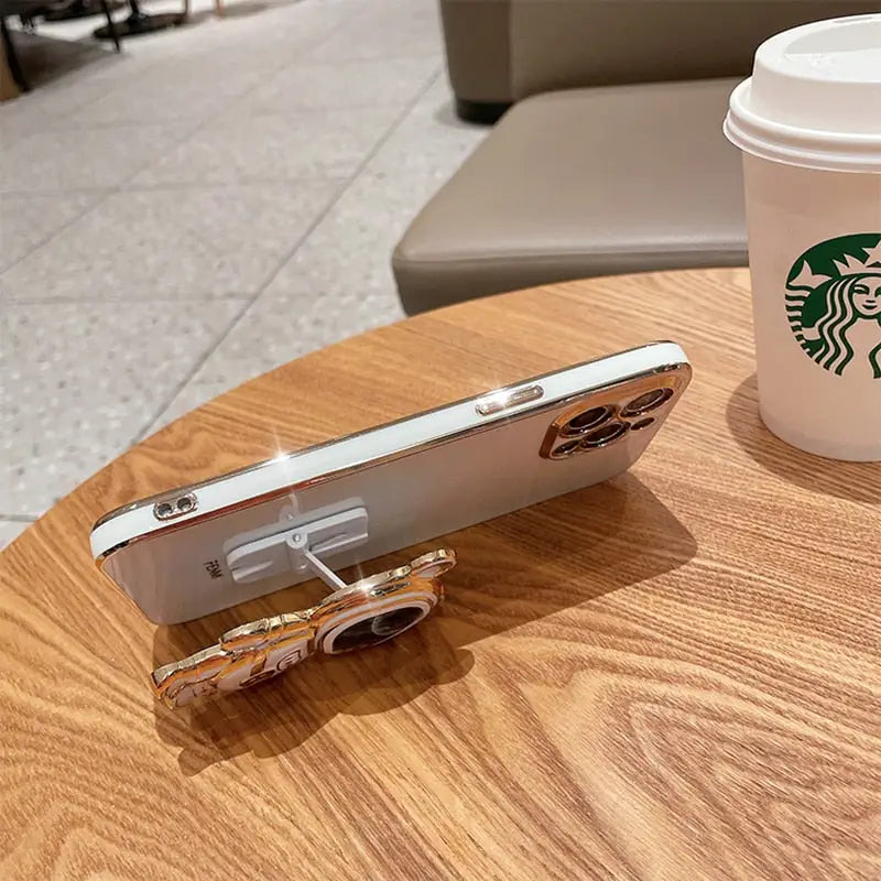 a cup of coffee and a cell phone on a table