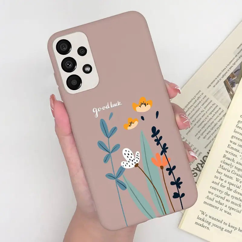 a woman holding a phone case with flowers on it