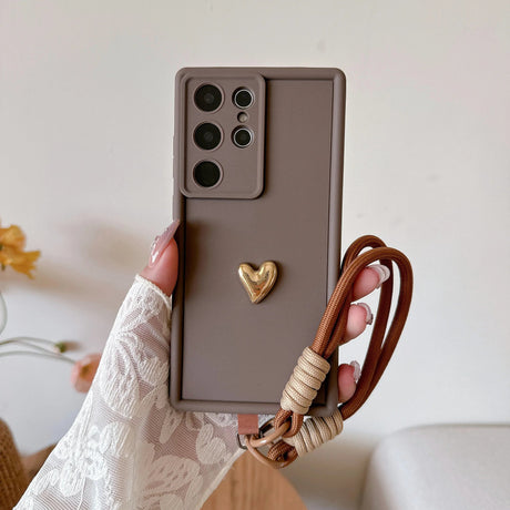 Taupe phone case with gold heart and brown strap.