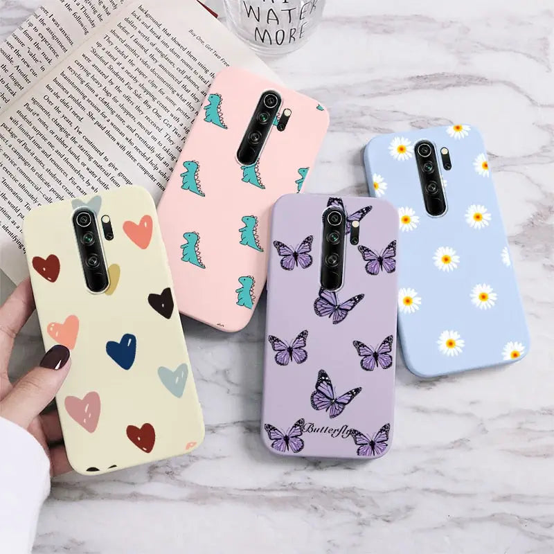 Three cases with hearts and butterflies on them are sitting on a table