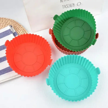 three different colored cupcakes in a box