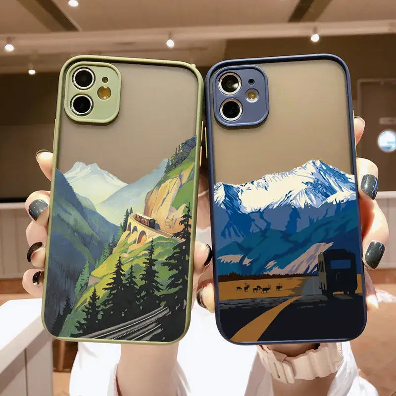 Two cases with mountains and trees on them