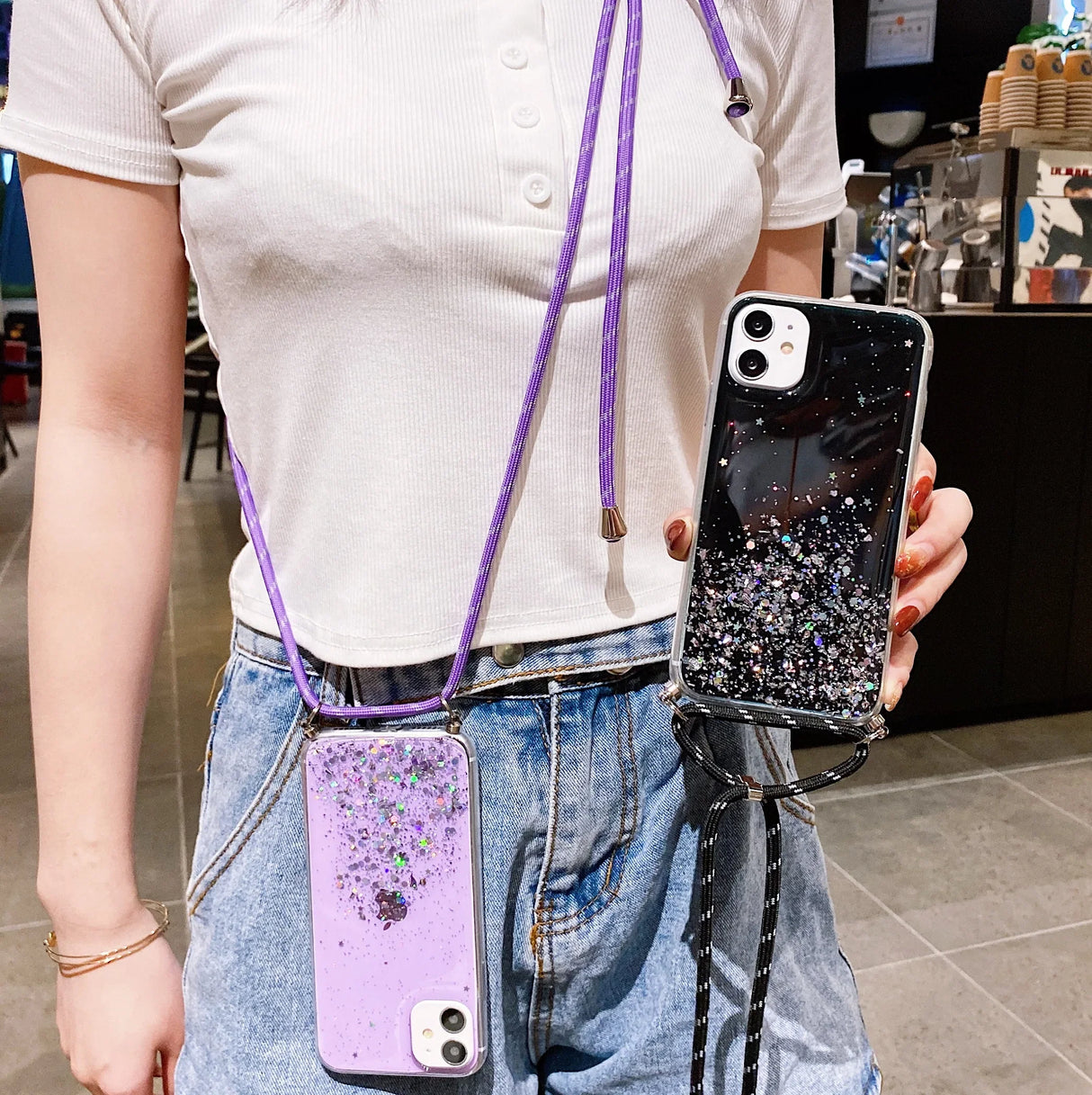 Two glitter phone cases on lanyards.