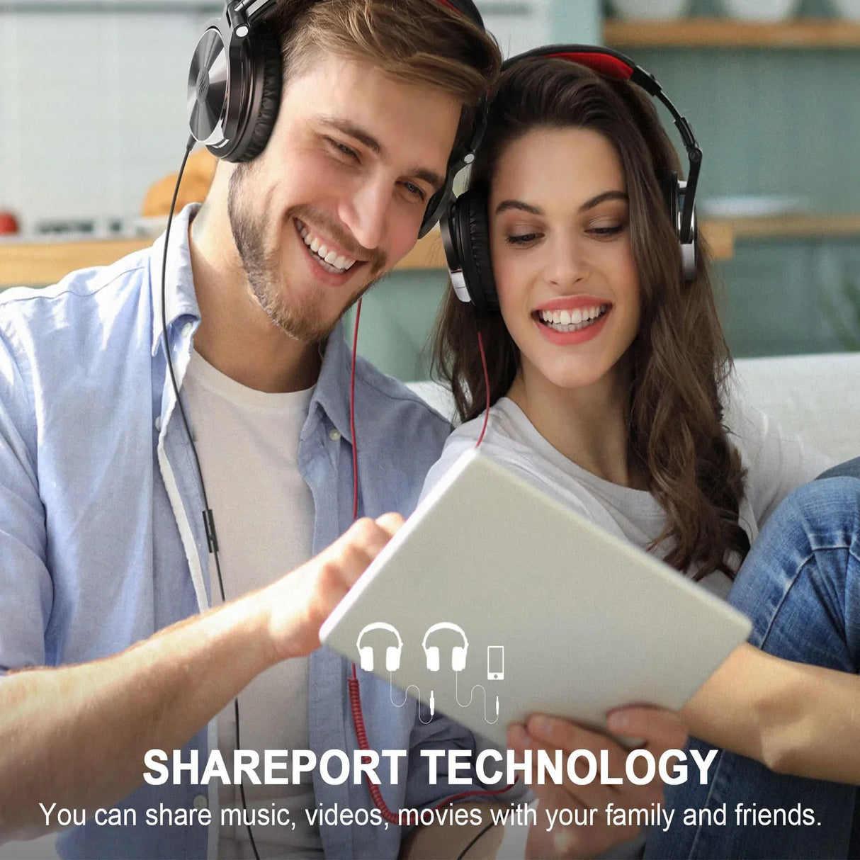 Two people wearing headphones and smiling while looking at a tablet device.