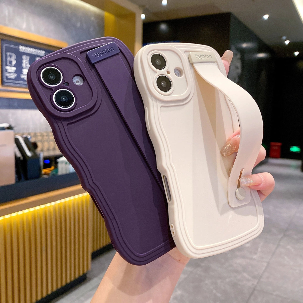 Two phone cases with hand straps.