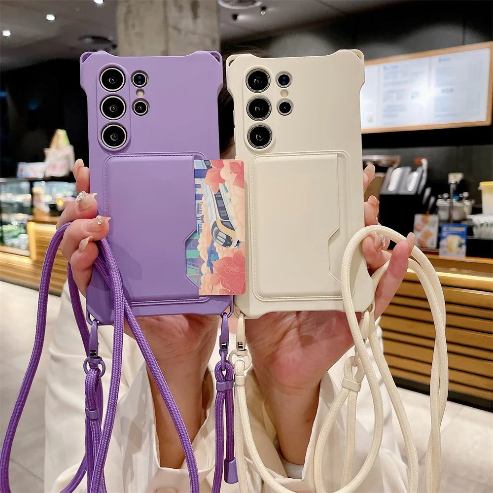 Two smartphone cases with attached lanyards and cardholders, one purple and one cream.