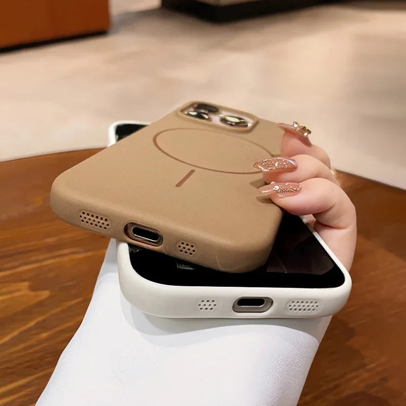 Two smartphone cases in beige and white, one with a visible charging port and speaker holes, and the other with camera cutouts and a circular magnetic charging design.