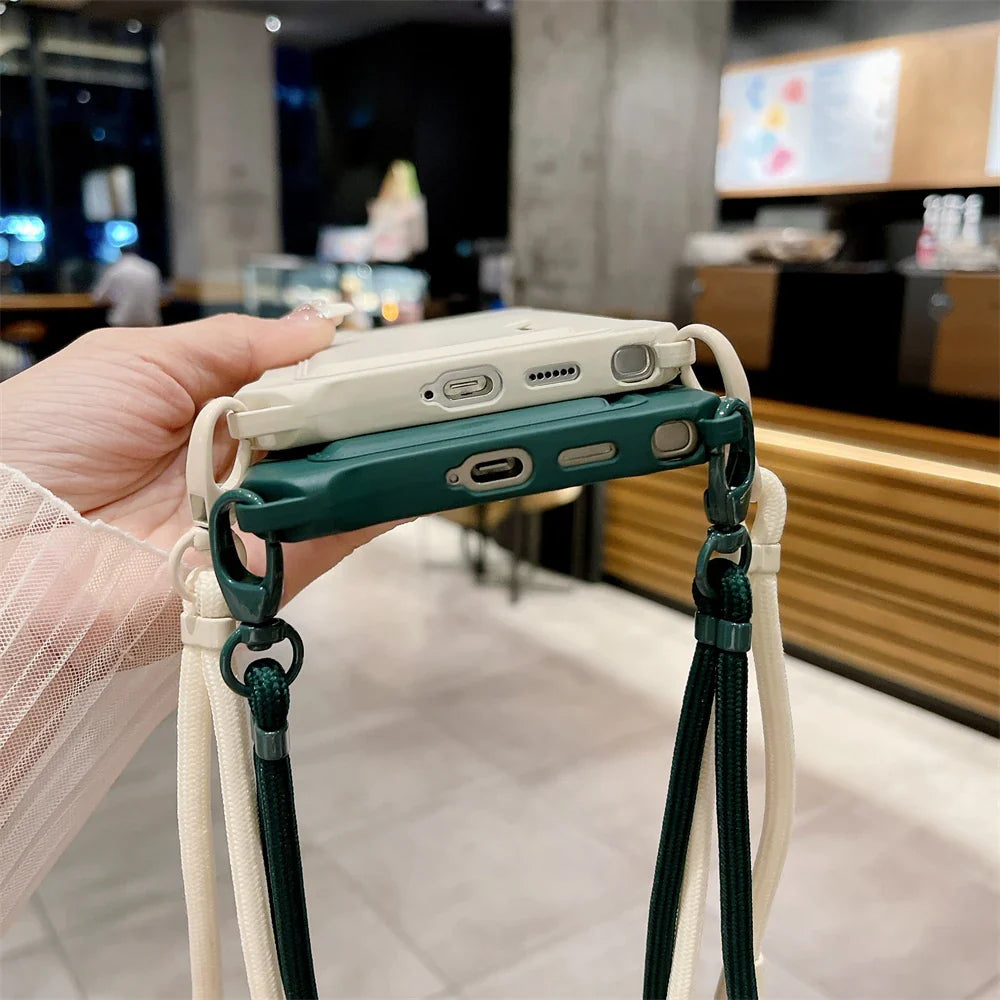 Two smartphone cases, one cream and one dark green, with attached lanyards.