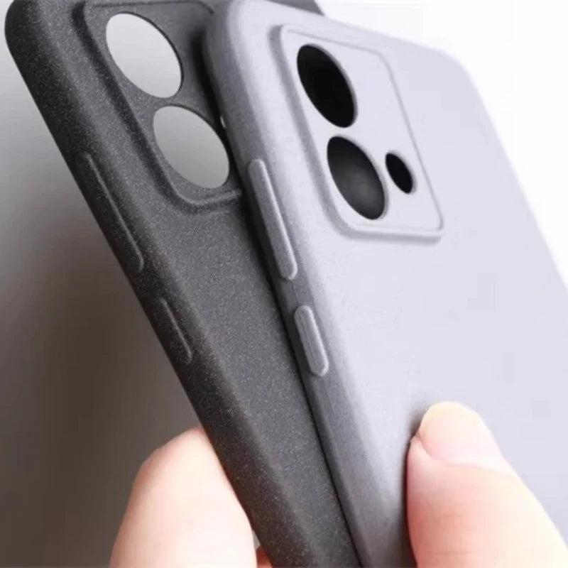 Two smartphone cases, one dark gray and one light gray, featuring raised button covers and distinct camera cutouts.