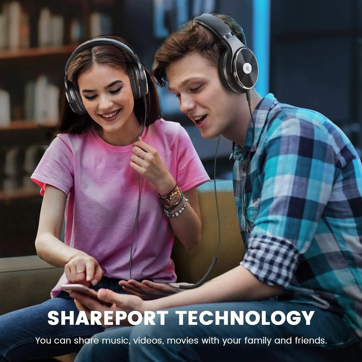 Two young people wearing headphones and looking at a mobile device together.