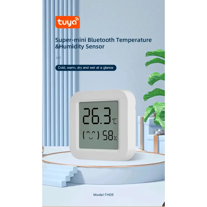 A white alarm clock sitting on top of a table next to a plant