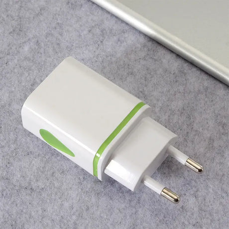 a white and green usb charger on a gray surface