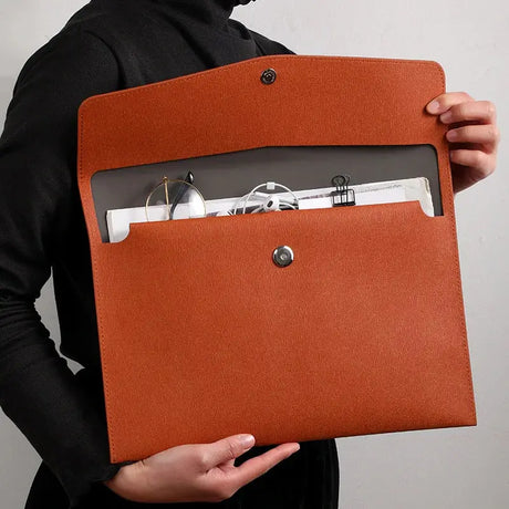 a woman holding a brown leather folder