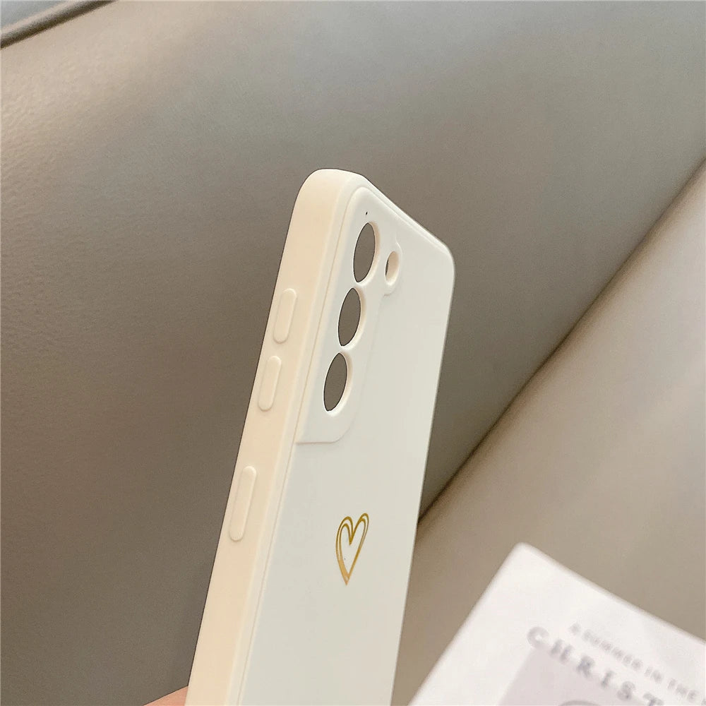 White phone case with a gold heart design