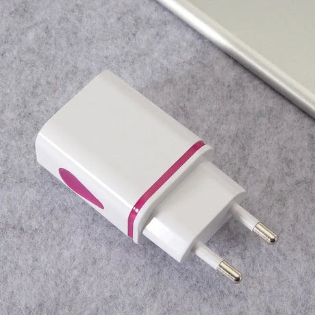 a white and pink usb charger on a gray surface