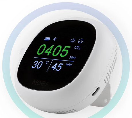 White, round, digital air quality monitor.