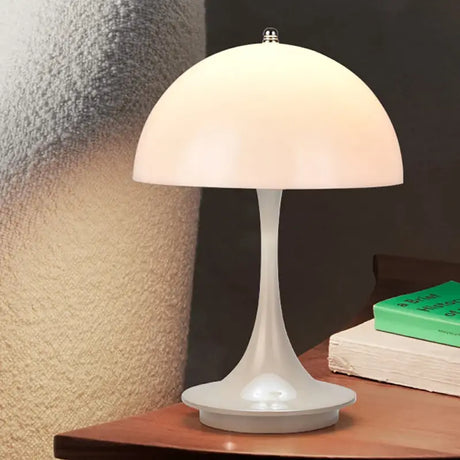 a white table lamp on a wooden table
