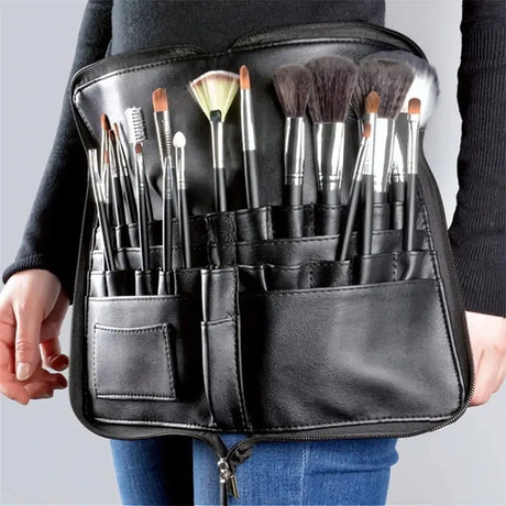 a woman holding a black leather makeup brush holder