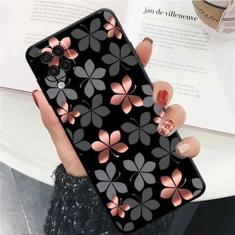 a woman holding a black and pink flower case