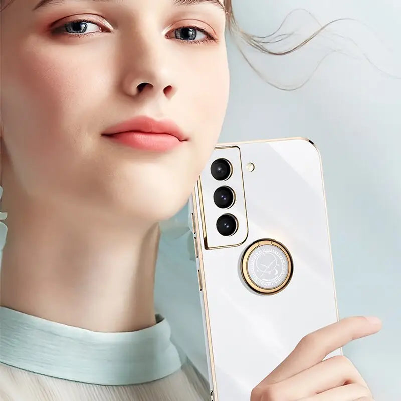 a woman holding a cell phone with a gold ring
