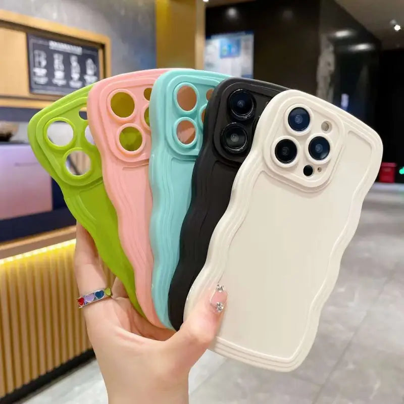 a woman holding up four iphone cases