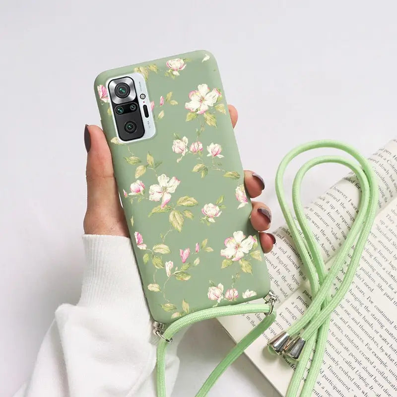 a woman holding a green phone case with flowers on it