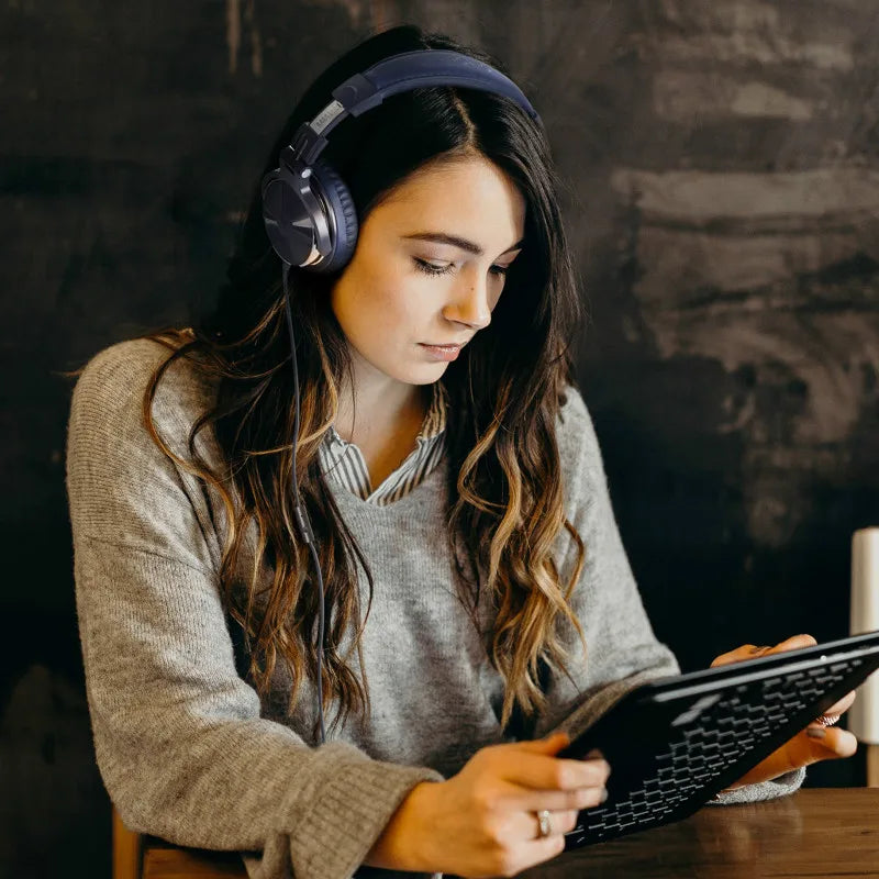 Woman wearing headphones and using a tablet device.