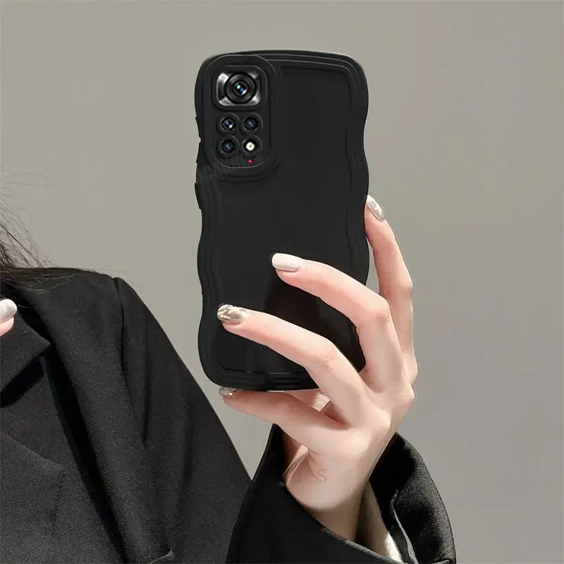 a woman holding a black iphone case