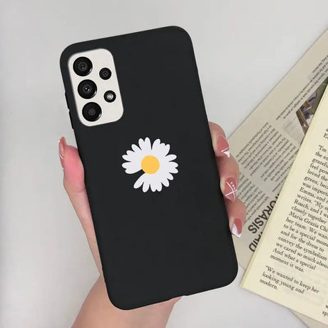a woman holding a phone case with a daisy on it