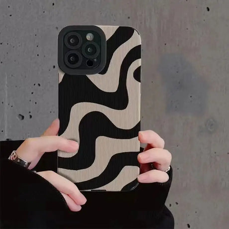 a woman holding a black and white phone case