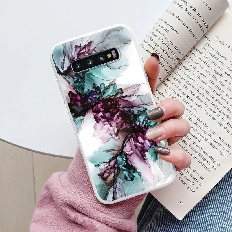 a woman holding a book and a phone case