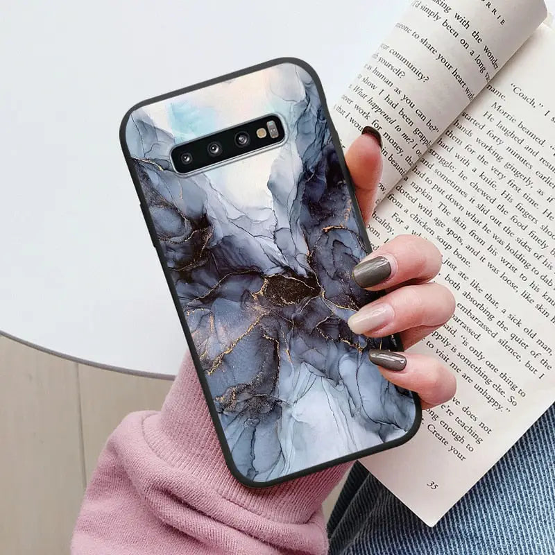 a woman holding a book and a phone case