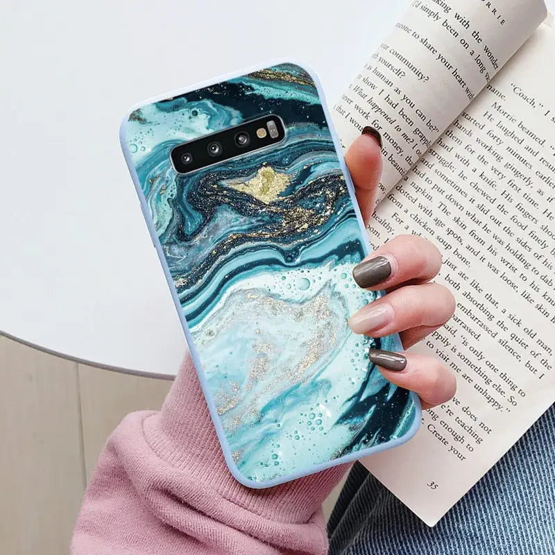 a woman holding a book and holding a phone case