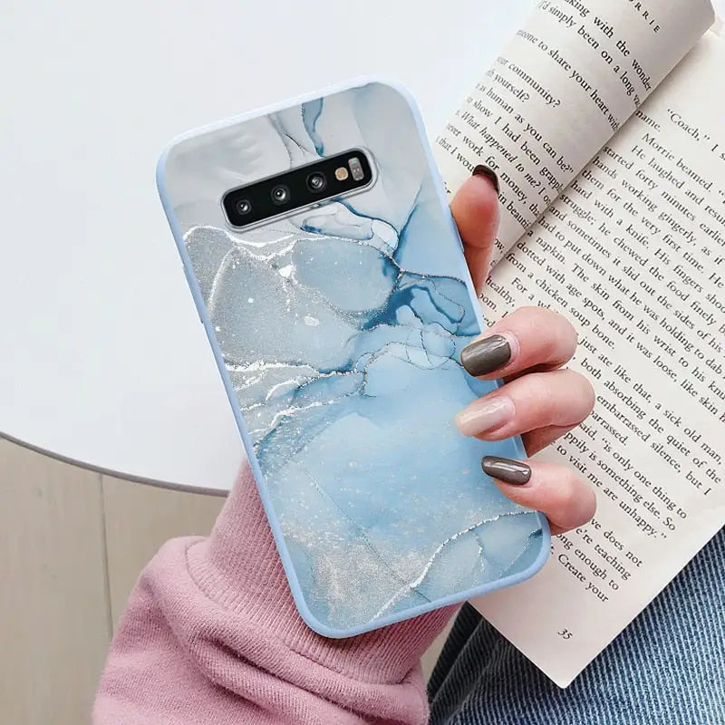 a woman holding a book and holding a phone case
