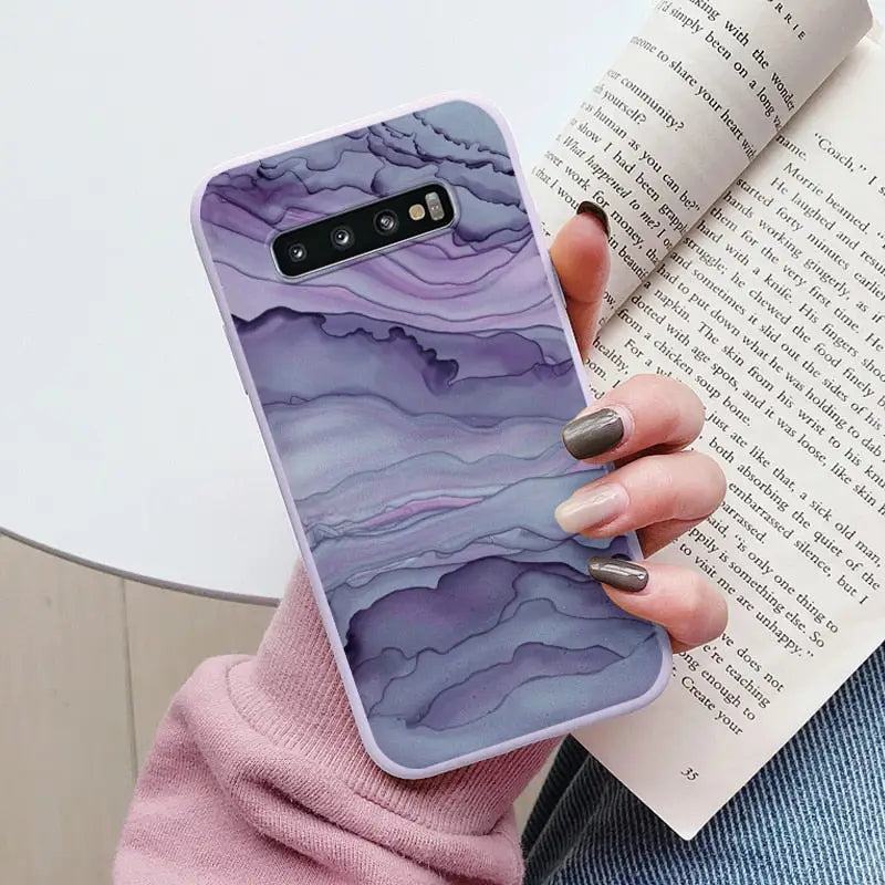 a woman holding a book and a phone case