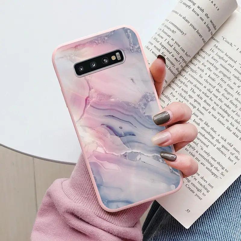 a woman holding a book and holding a phone case
