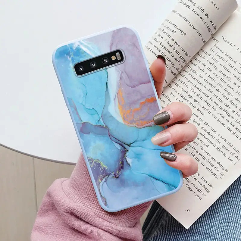 a woman holding a book and holding a phone case