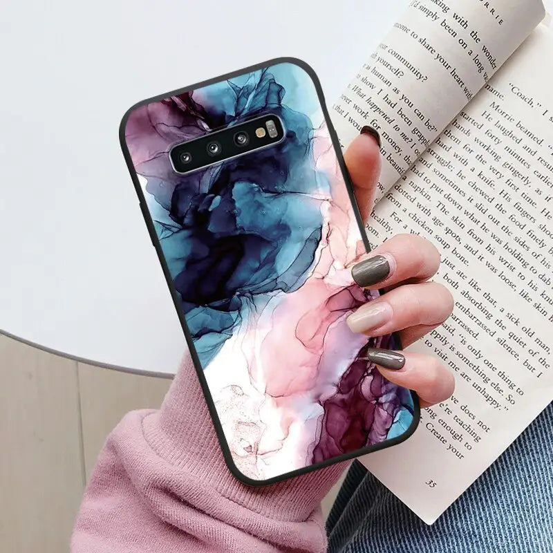 a woman holding a book and a phone case