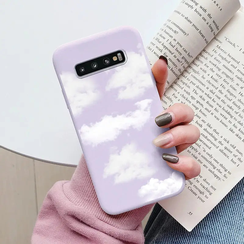 a woman holding a book and a phone case