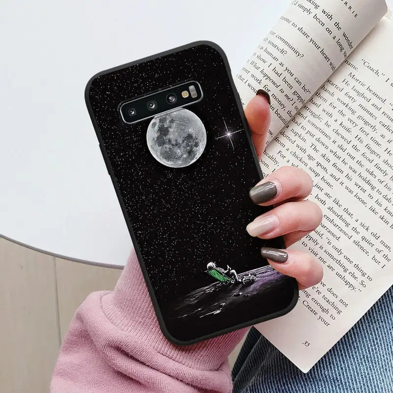 a woman holding a book and a phone case