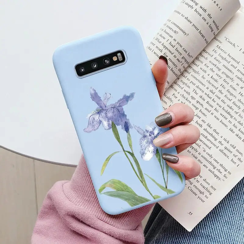 a woman holding a book and a phone case