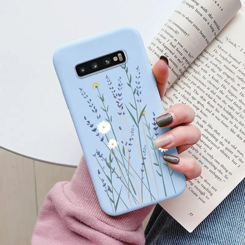 a woman holding a book and a phone case