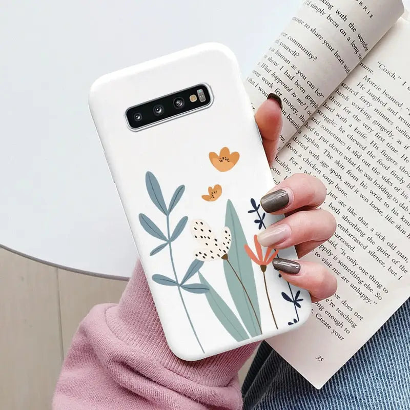 a woman holding a book and a phone case